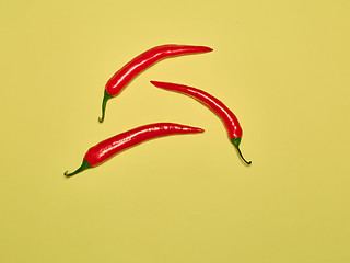 Image showing bitter chili pepper and paprika on a yellow background