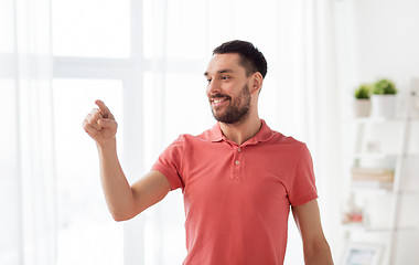 Image showing happy man touching something imaginary at home