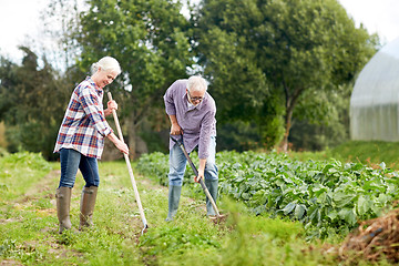 Image showing senior couple with shovels at garden or farm