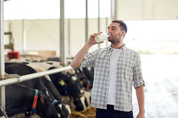 Image showing man or farmer drinking cows milk on dairy farm