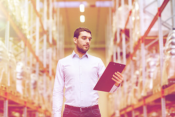 Image showing businessman with clipboard at warehouse