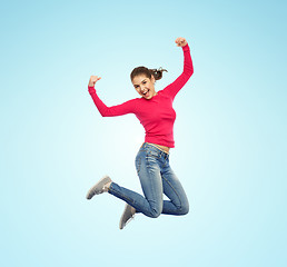 Image showing smiling young woman jumping in air