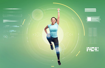 Image showing happy smiling sporty young woman jumping in air