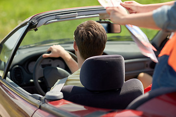 Image showing happy friends with map driving in convertible car