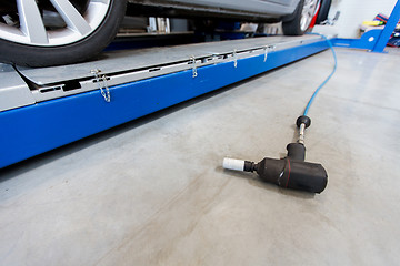 Image showing screwdriver and car at tire shop