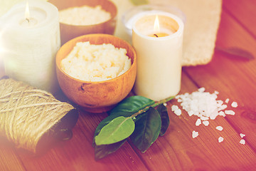 Image showing close up of natural body scrub and candles on wood