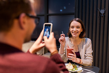 Image showing happy couple with smartphone at vegan restaurant