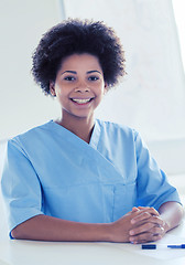 Image showing happy doctor or nurse with clipboard at hospital