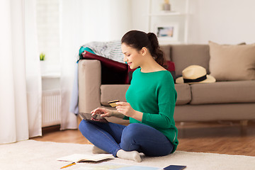 Image showing woman with tablet pc and credit card at home