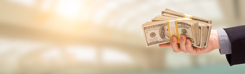 Image showing Male Hand Holding Stack of Cash Wide Banner With Room For Copy.