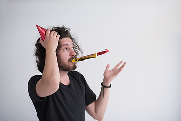 Image showing Portrait of a man in party hat blowing in whistle