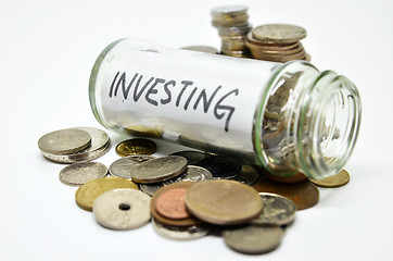 Image showing Investment lable in a glass jar with coins spilling out