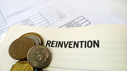 Image showing Reinvention word on the book with balance sheet 