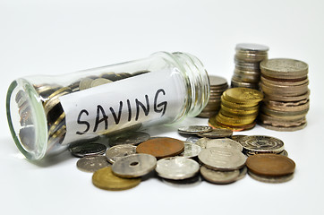 Image showing Saving lable in a glass jar with coins spilling out