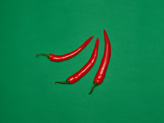 Image showing bitter chili pepper and paprika on a green background