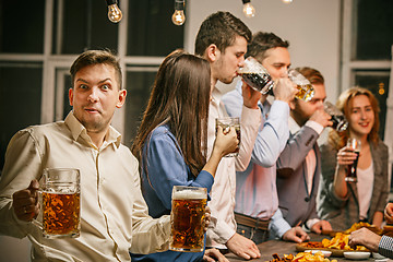 Image showing Group of friends enjoying evening drinks with beer