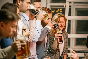 Image showing Group of friends enjoying evening drinks with beer