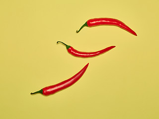 Image showing bitter chili pepper and paprika on a yellow background