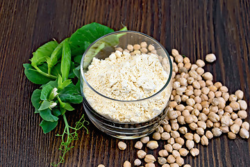 Image showing Flour chickpeas in glassful with green peas on board