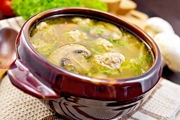 Image showing Soup with meatballs and mushrooms in clay bowl on board