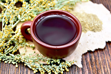 Image showing Tea with wormwood in clay cup on rough paper