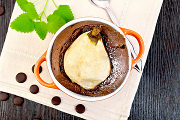 Image showing Cake chocolate with pear in red bowl on napkin top