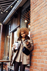 Image showing young pretty african american women drinking coffee outside in c