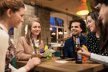 Image showing friends with drinks, money and bill at bar