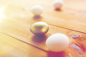 Image showing close up of golden and white easter eggs on wood