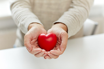 Image showing close up of senior man with red heart in hands