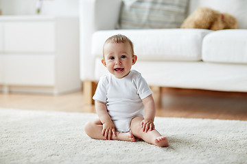 Image showing happy baby boy or girl sitting on floor at home