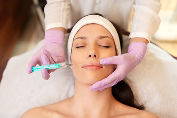 Image showing beautician doing beauty injection to woman lips