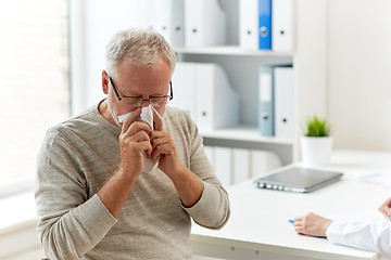 Image showing senior man blowing nose with napkin at hospital