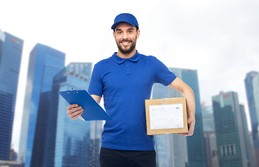 Image showing happy delivery man with parcel box and clipboard