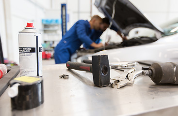 Image showing working tools and men repairing car at workshop