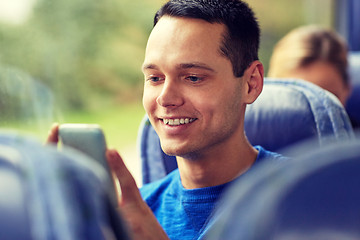 Image showing happy man sitting in travel bus with smartphone