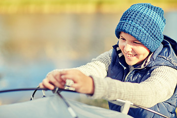 Image showing happy boy setting up tent outdoors