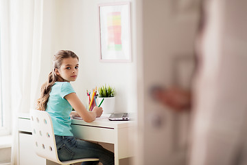 Image showing girl with laptop writing to notebook at home