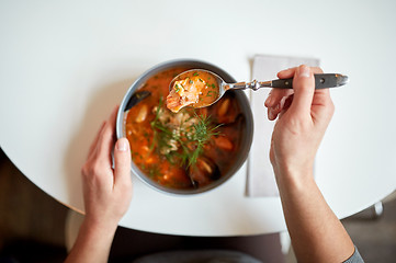 Image showing woman eating seafood soup at restaurant