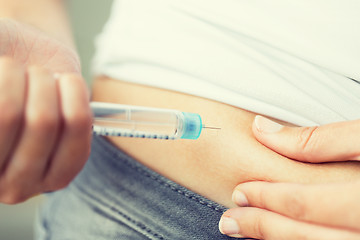 Image showing close up of hands making injection by insulin pen