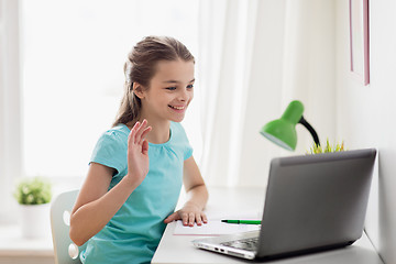 Image showing happy girl with laptop waving hand at home