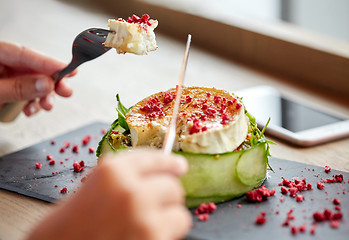 Image showing woman eating goat cheese salad at restaurant