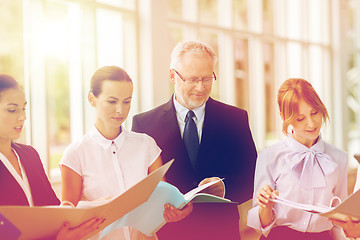 Image showing business team with tablet pc and folders at office