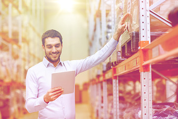 Image showing happy businessman with tablet pc at warehouse