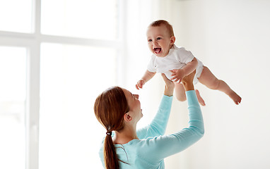 Image showing happy young mother with little baby at home