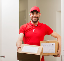 Image showing delivery man with parcel boxes at customer door