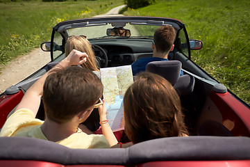 Image showing happy friends with map driving in convertible car