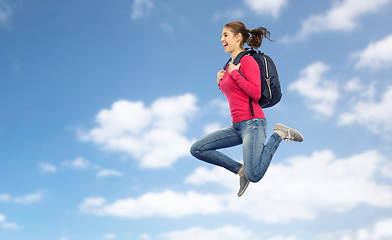 Image showing happy woman or student with backpack jumping