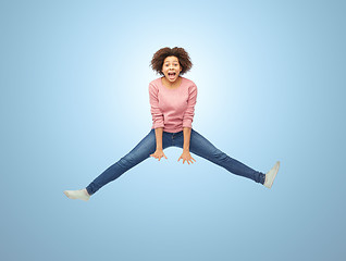 Image showing happy african american woman jumping over white