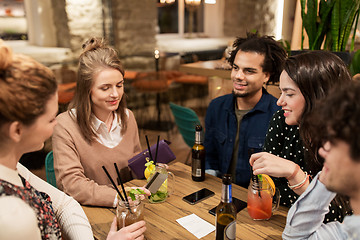 Image showing friends with drinks, credit card and bill at bar